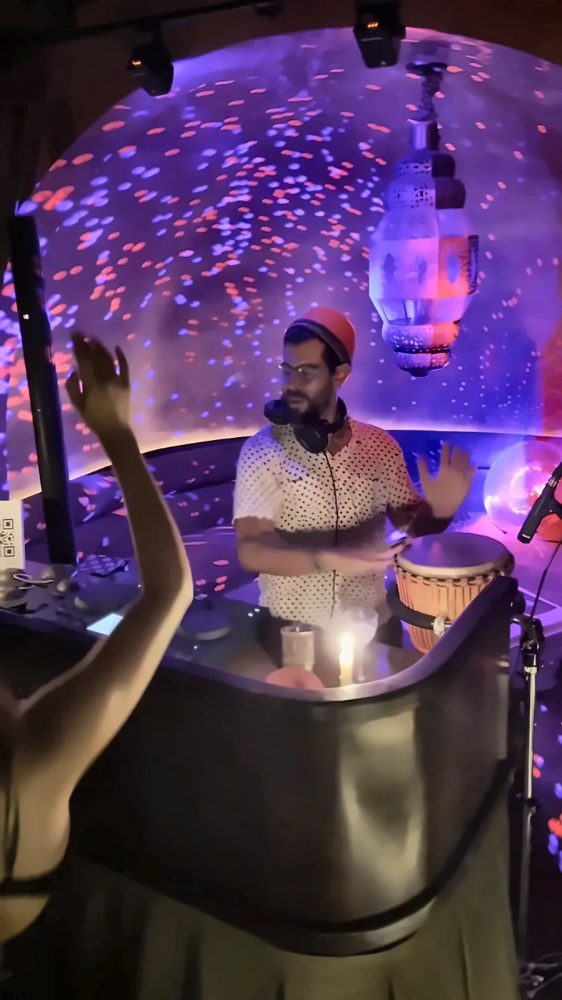 A dancer raises her hand while Taïb plays