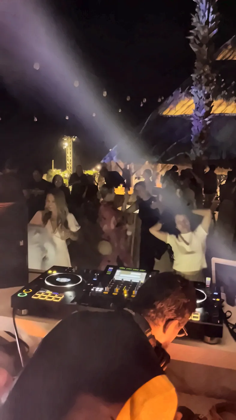 Hands in the air under the lasers at a night party