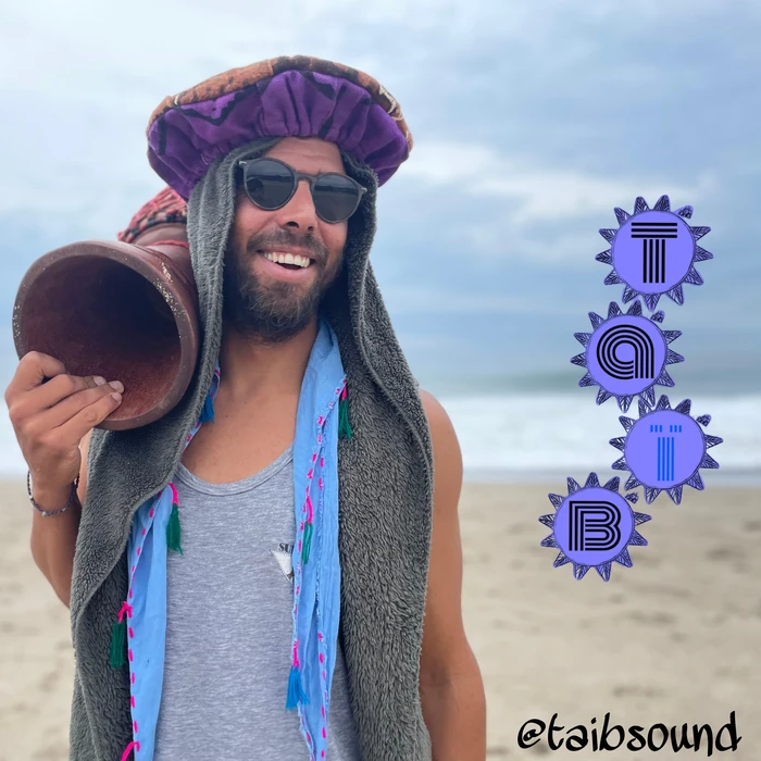 Taïb on the beach with his djembe on his shoulder